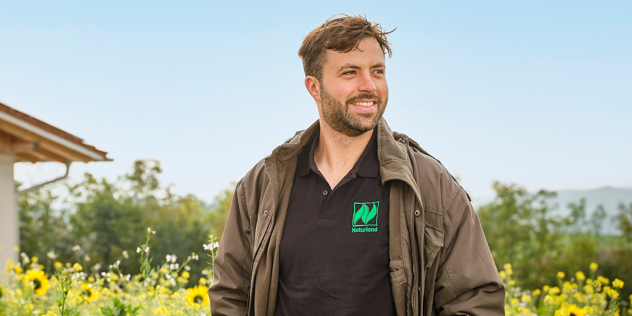 Naturland-Landwirt Stefan Meier steht vor einer blühenden Anbaufläche.