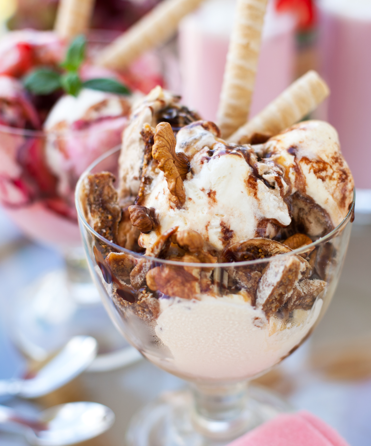 
Eisbecher mit Vanilleeis, Schokoladensauce, Nüssen und Waffelröllchen.