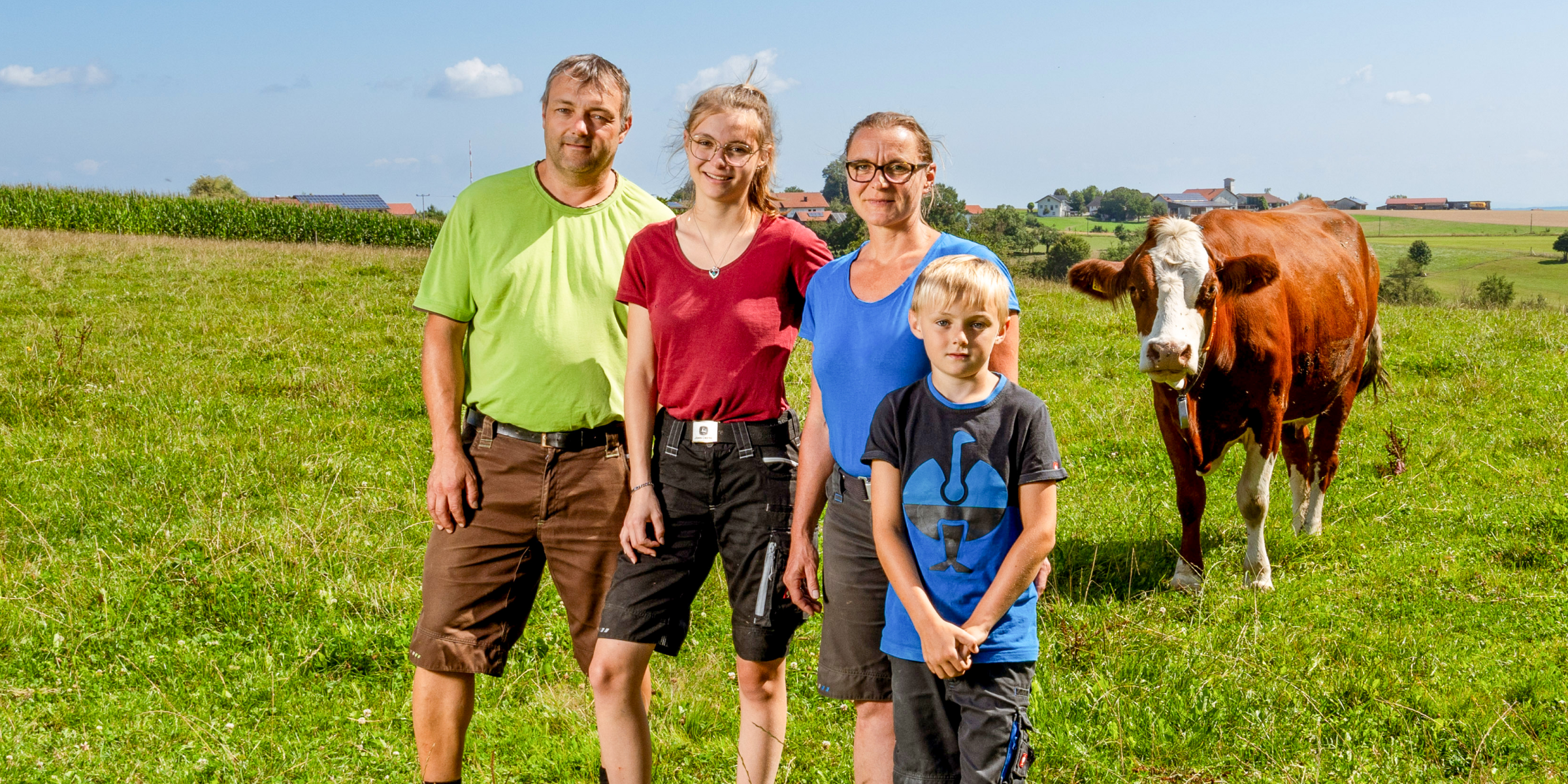 Familie Karch neben Kuh auf der Weide.